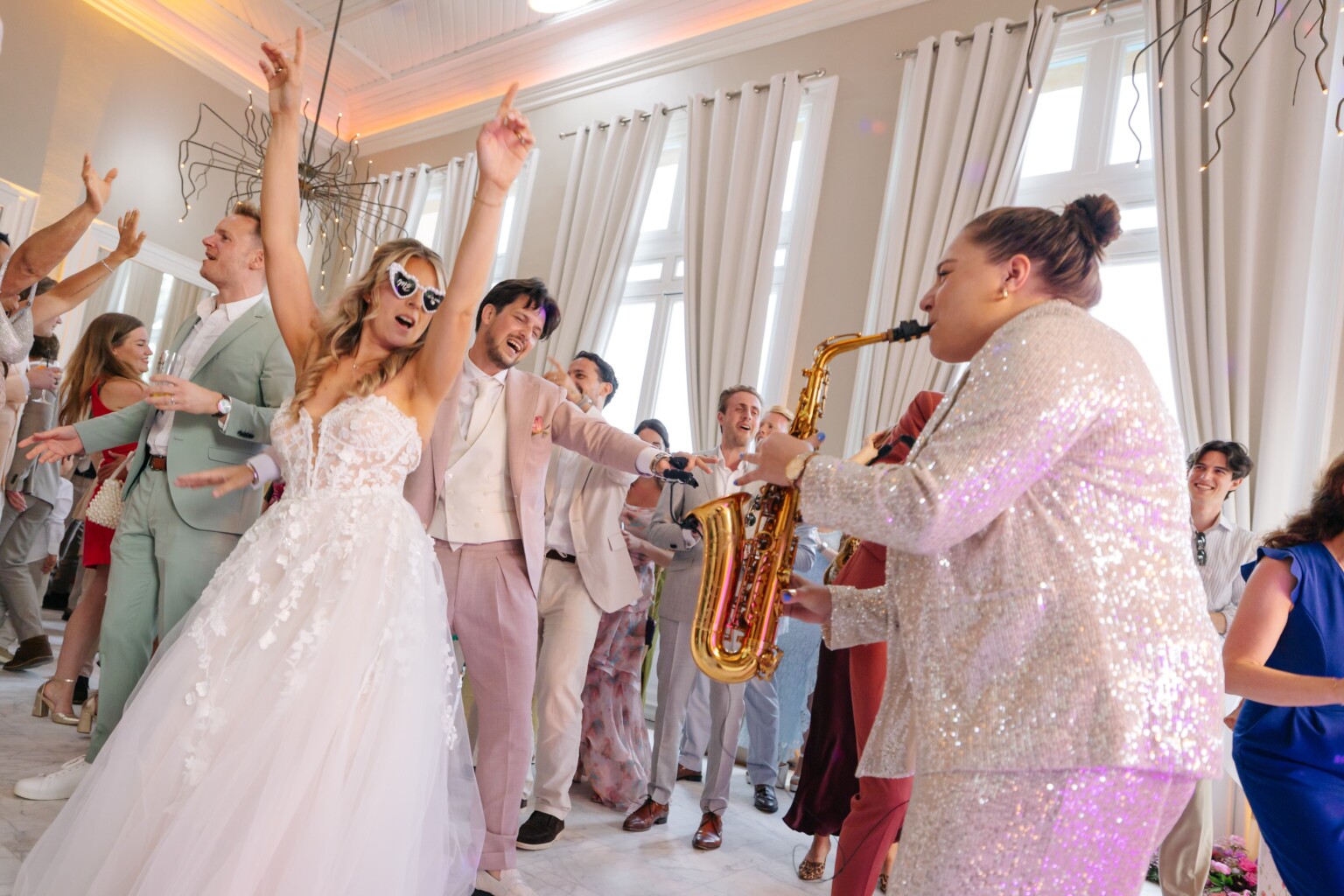 Bride and groom dancing with a saxophonist on the dance floor